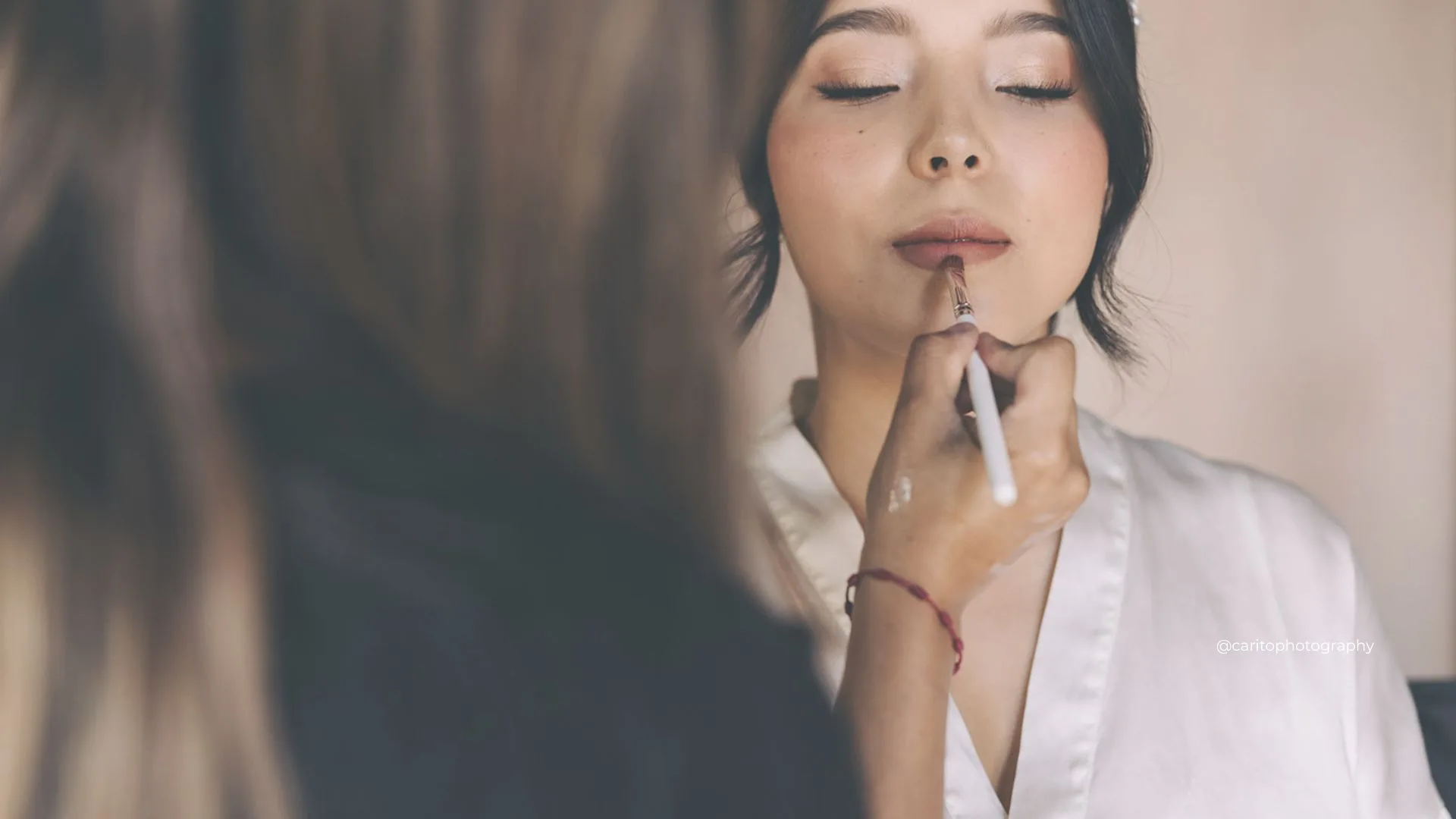 Bridal makeup artist refining a natural lip look