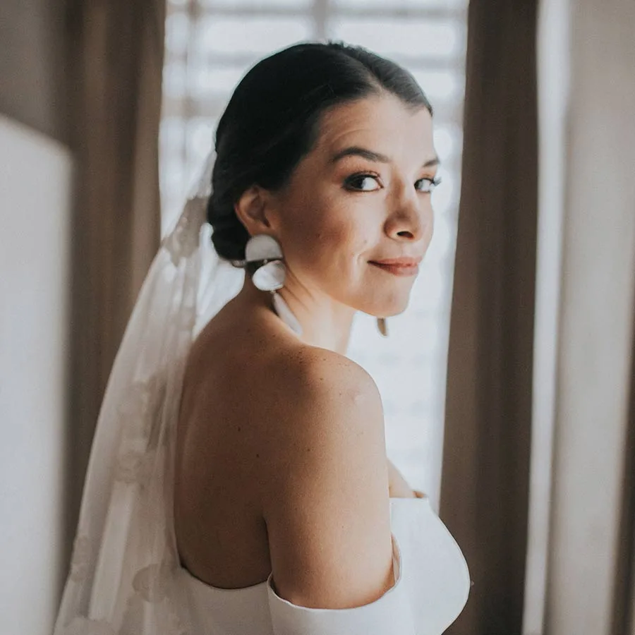 Elegant bridal updo and luminous makeup with statement earrings