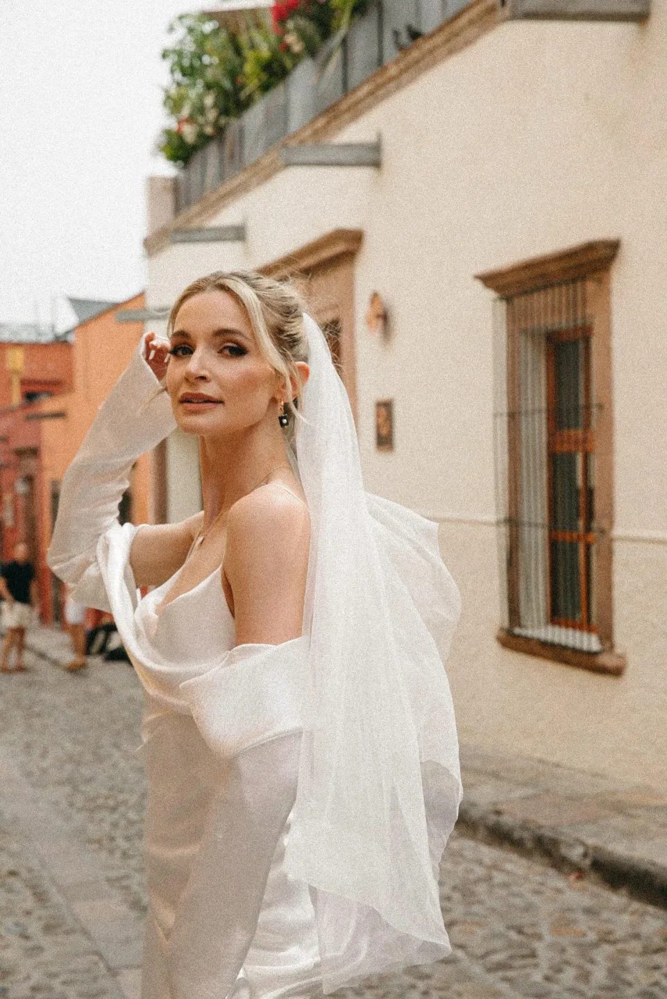 Bride with natural makeup and a flowing veil on a San Miguel street
