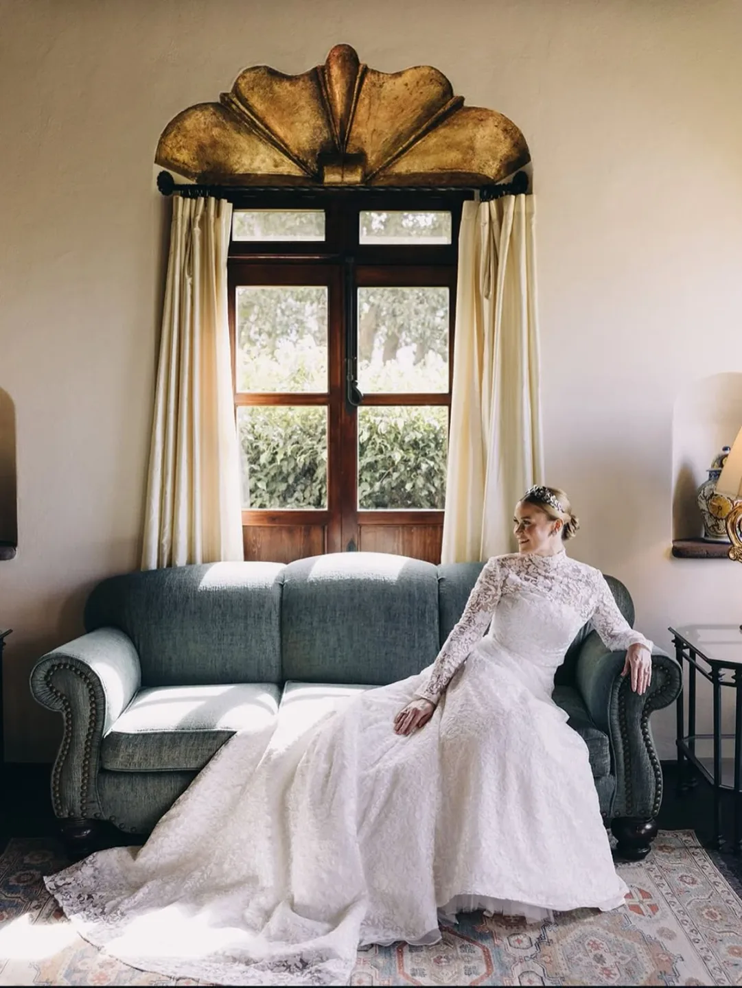 Bride in a light-filled room with polished wedding hair and makeup
