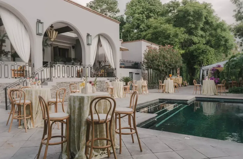 Poolside cocktail reception arranged with high-top tables and lounge seating
