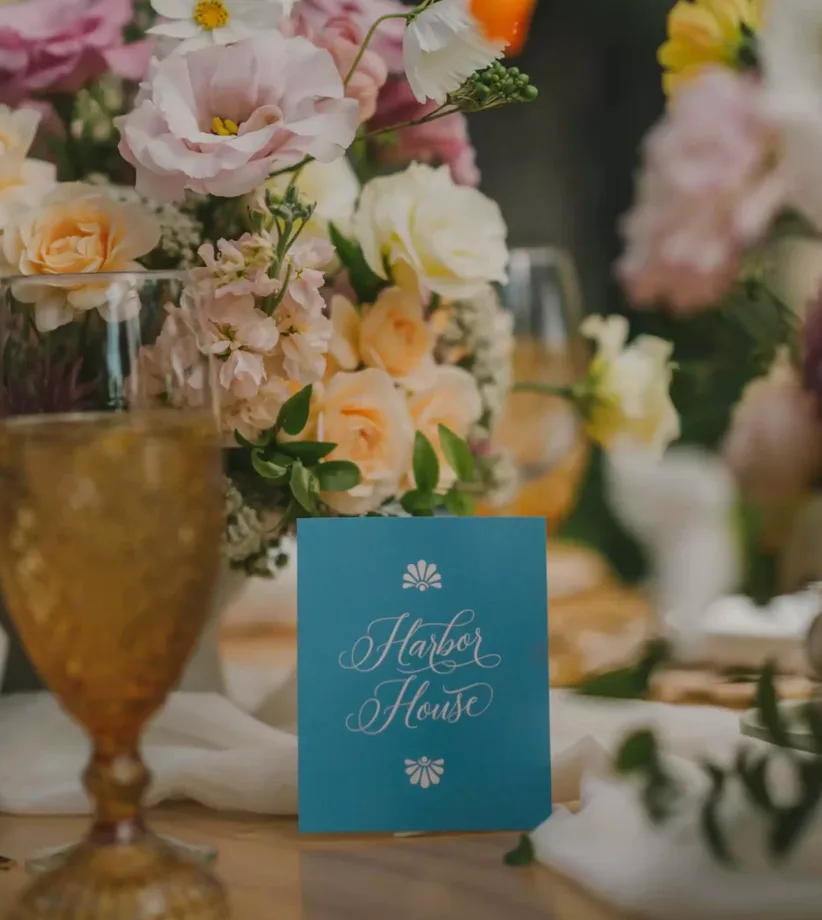 Pastel floral centerpiece and amber glassware on a wedding table