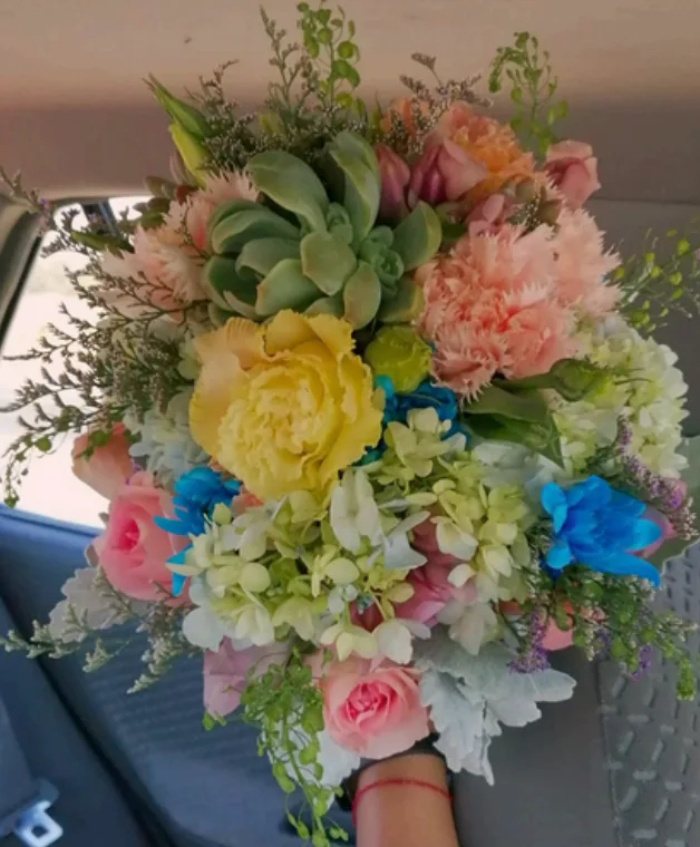 Colorful hand-tied bouquet with roses, hydrangeas, carnations and succulents
