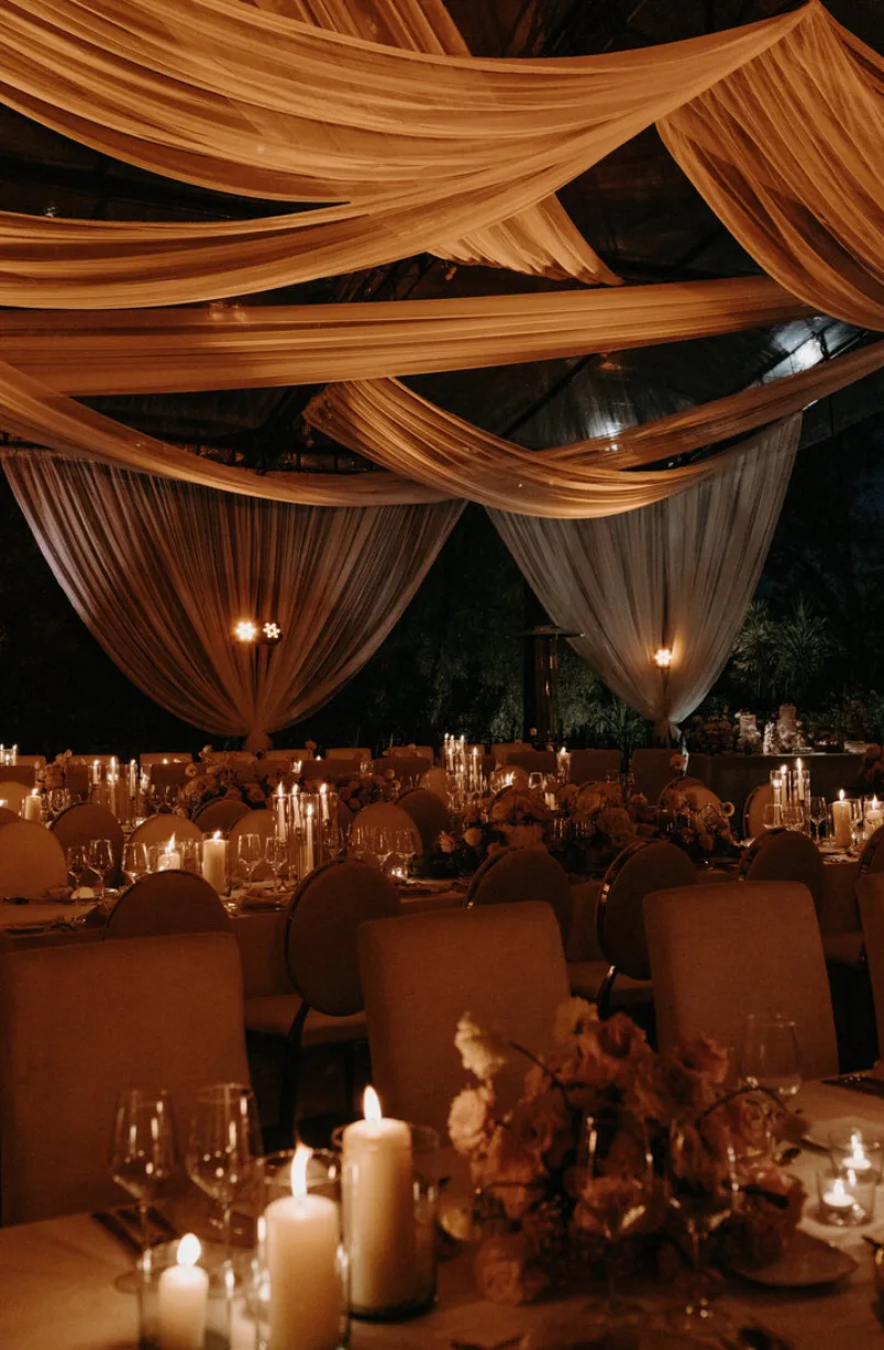 Candlelit wedding reception with dramatic fabric draping