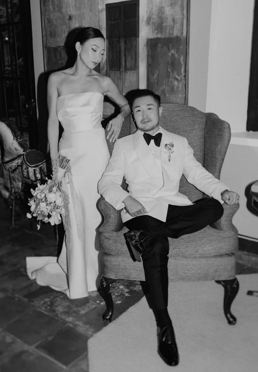 Black-and-white editorial wedding portrait of a bride and groom