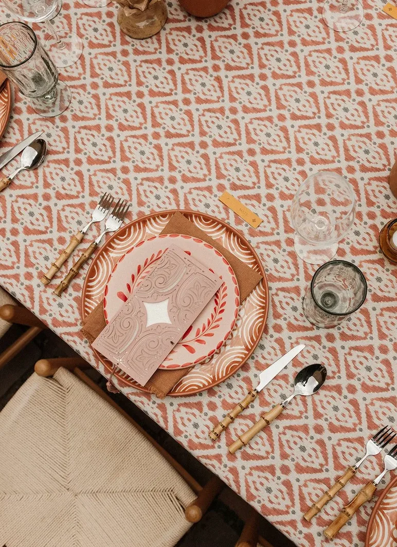 Terracotta wedding place setting with patterned linens and artisan tableware