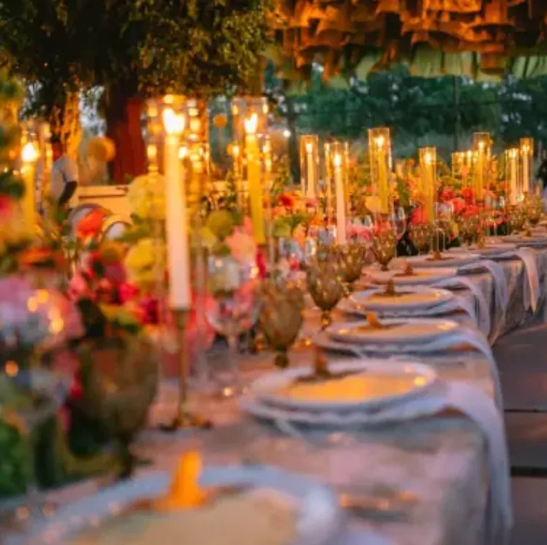 Candlelit wedding table with colorful floral arrangements designed by Penzi Weddings