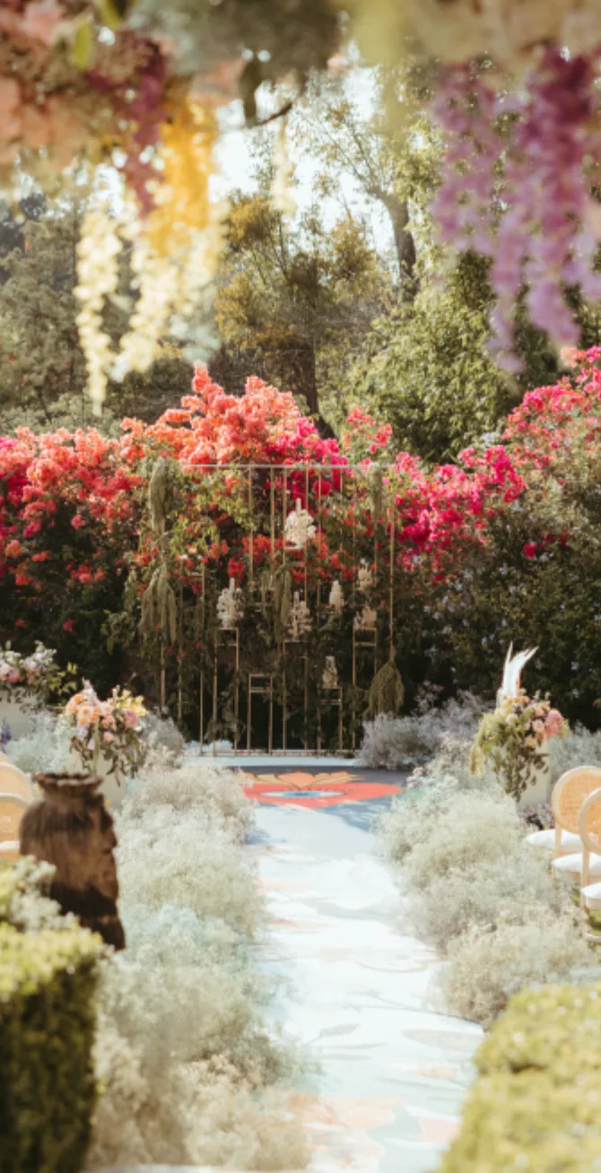 Garden ceremony aisle with airy white flowers, colorful accents and hanging blooms