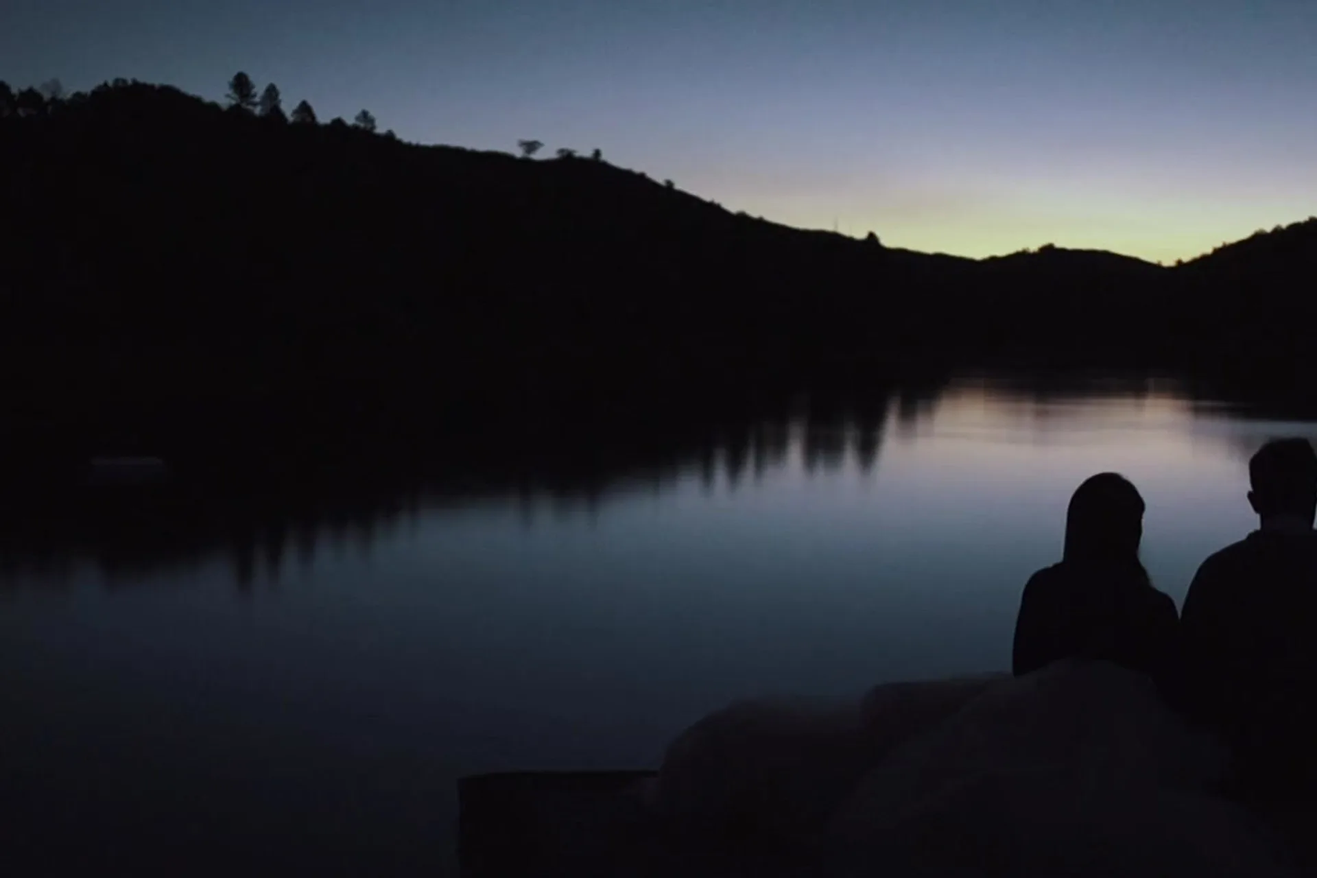 Cinematic silhouette of a couple beside the water