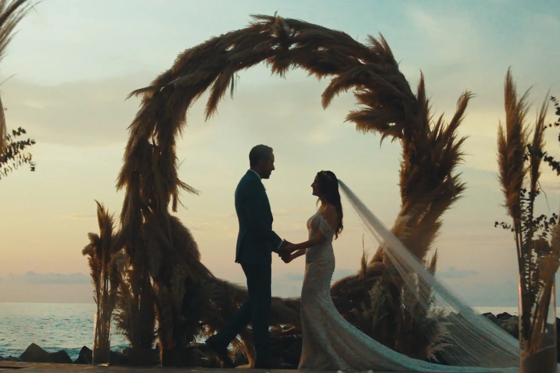 Wedding couple framed beneath a ceremonial arch