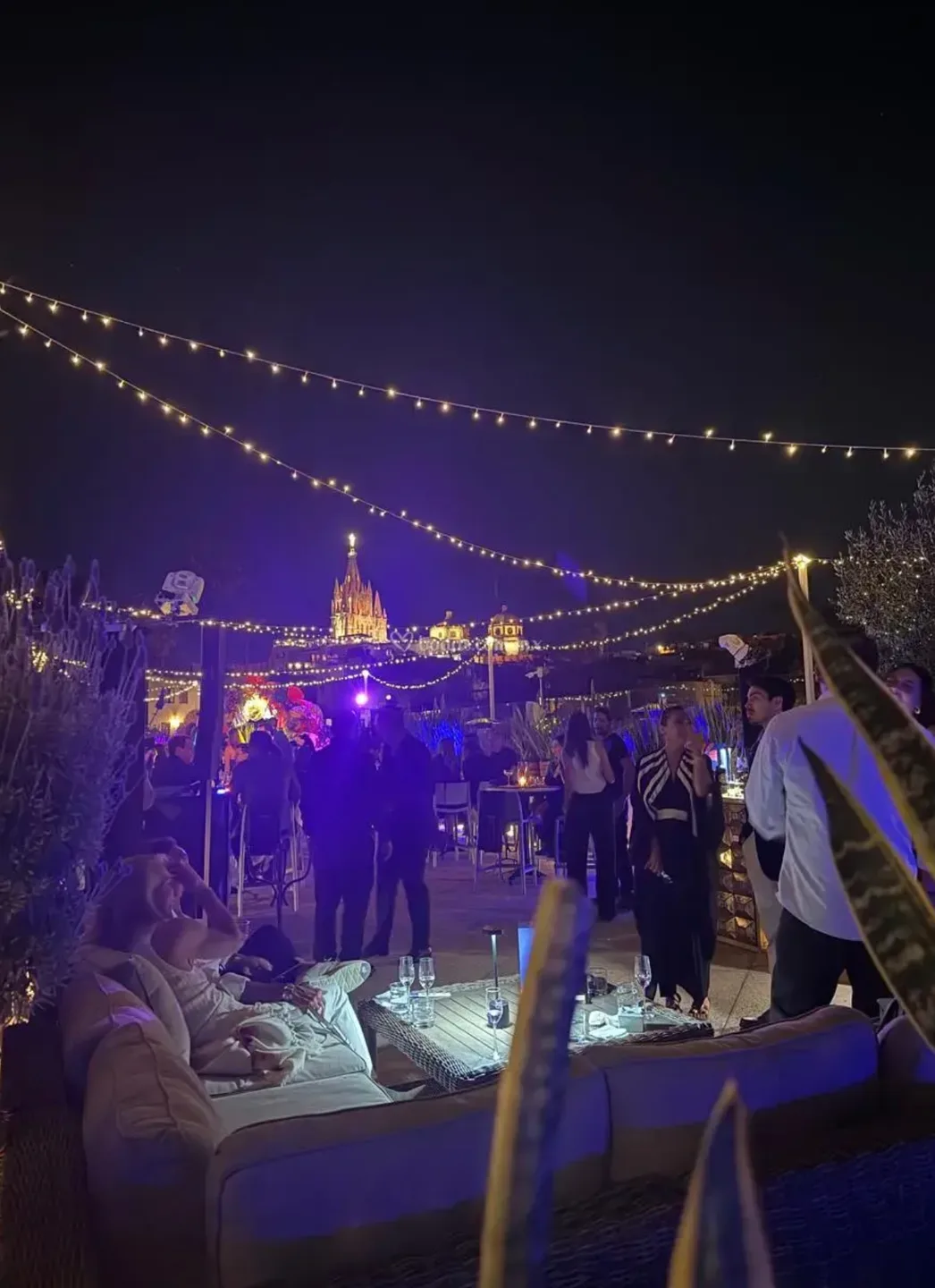 Evening rooftop celebration under string lights at Casa 1810
