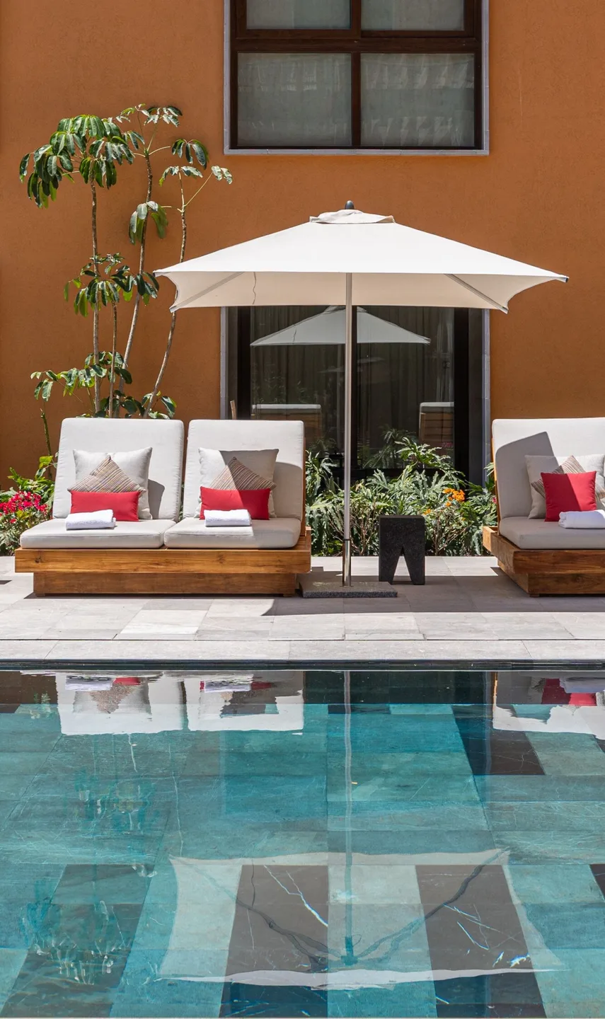 Poolside seating in an interior courtyard at Cleviá San Miguel de Allende