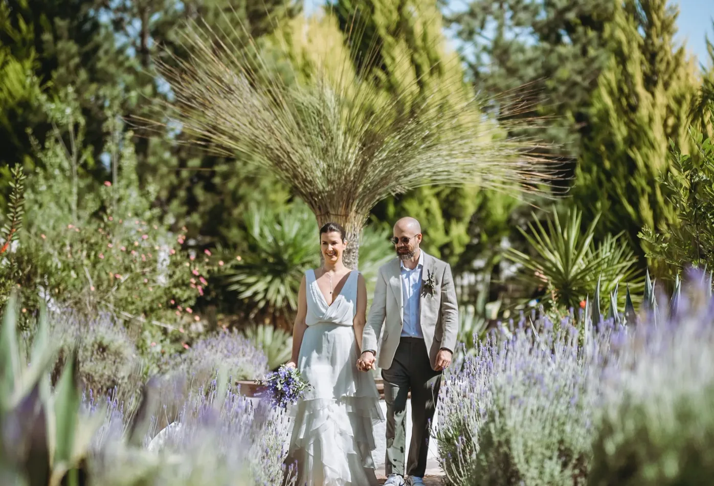 Newlyweds walking through Hacienda Agualuna's landscaped garden