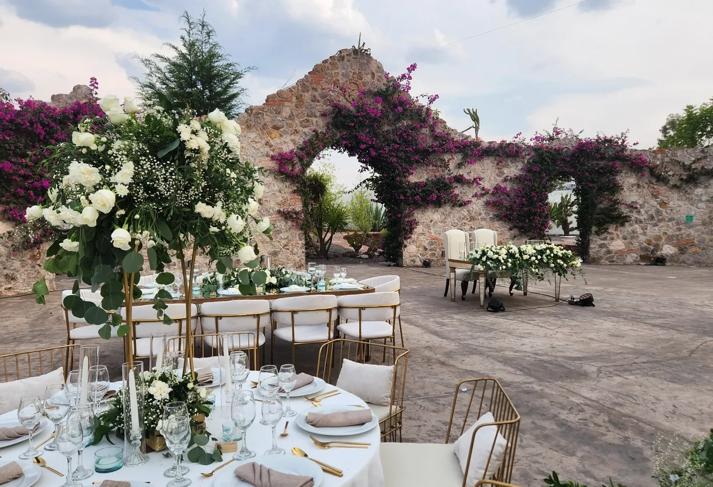 Outdoor wedding reception beneath bougainvillea-covered stone arches at Hacienda Agualuna