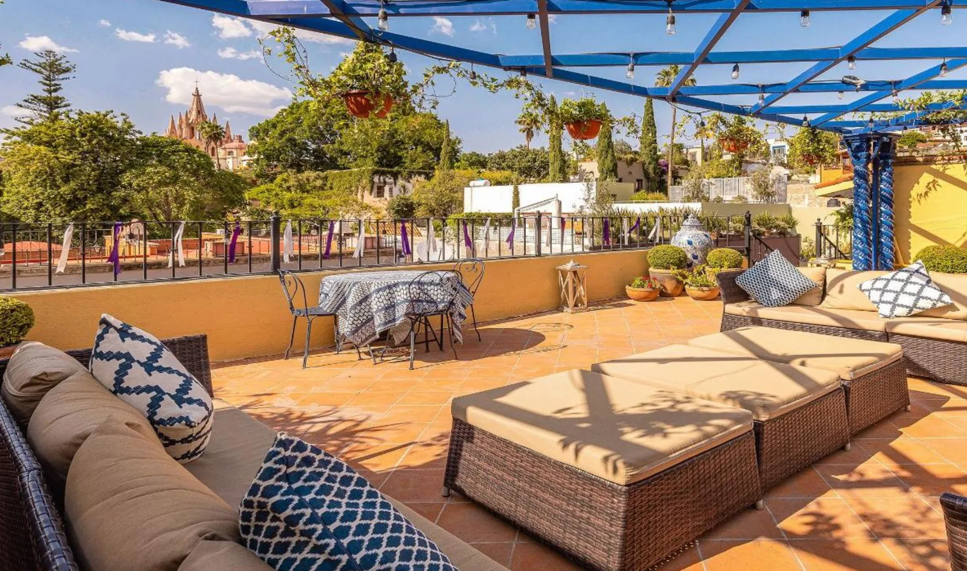 Rooftop terrace with lounge seating and views toward the Parroquia