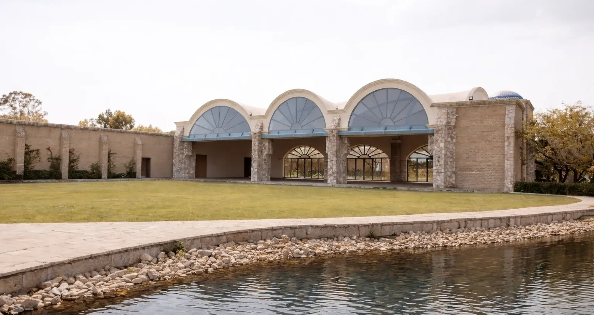 Vaulted event hall and waterfront lawn at Hacienda Los Arcángeles