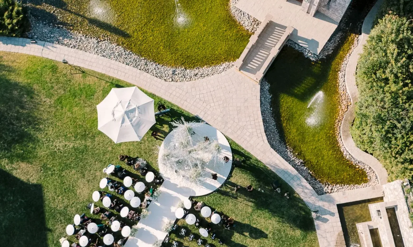 Aerial view of an outdoor wedding ceremony beside the water gardens