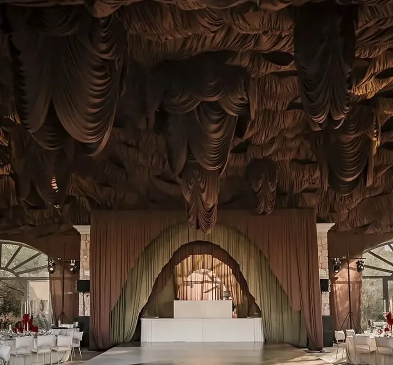 Indoor wedding reception with dramatic draping and a central dance floor