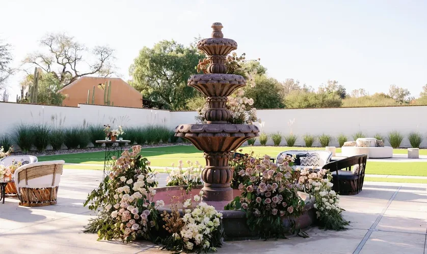Hacienda fountain surrounded by flowers and outdoor lounge seating
