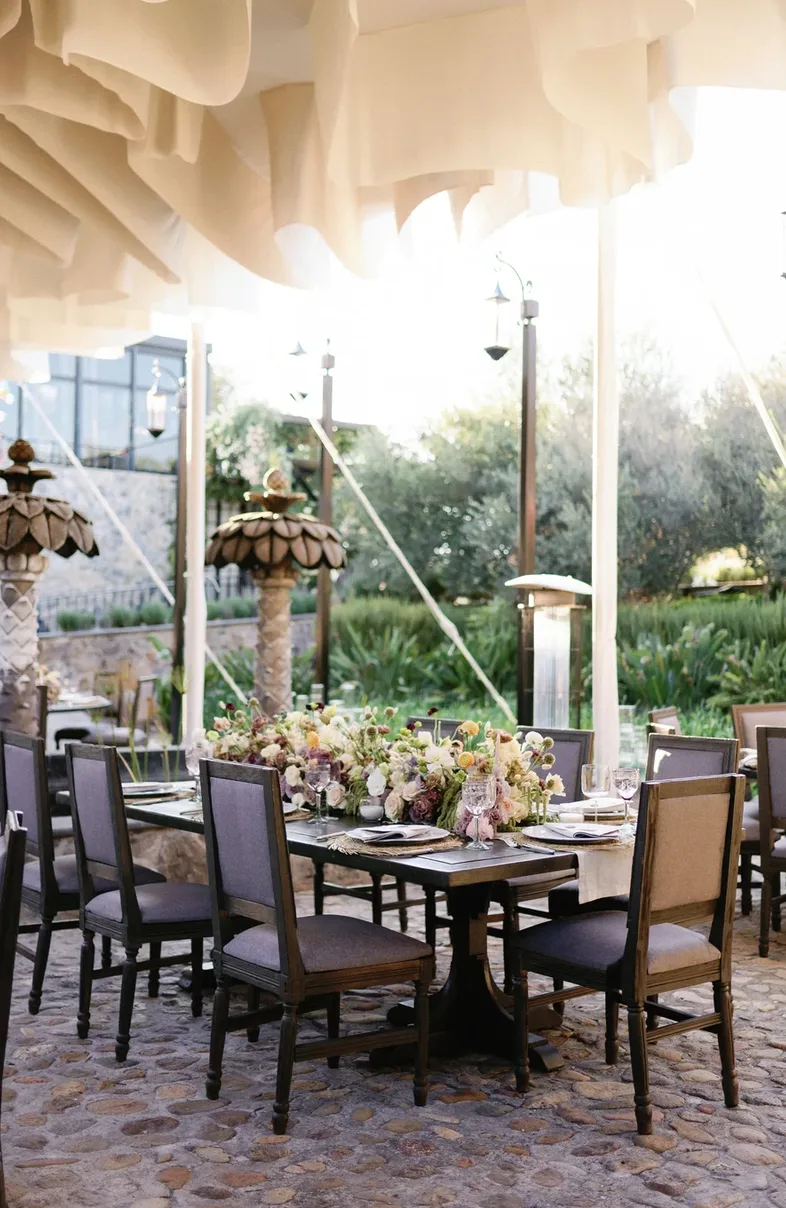 Floral reception tables beneath a fabric canopy on the garden terrace