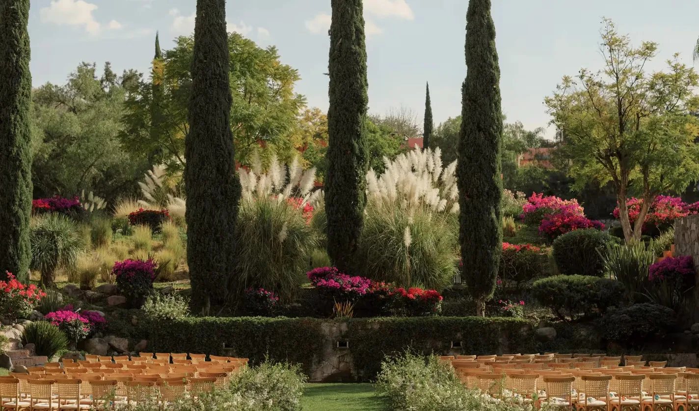 Garden wedding ceremony framed by cypress trees at Rosewood San Miguel de Allende